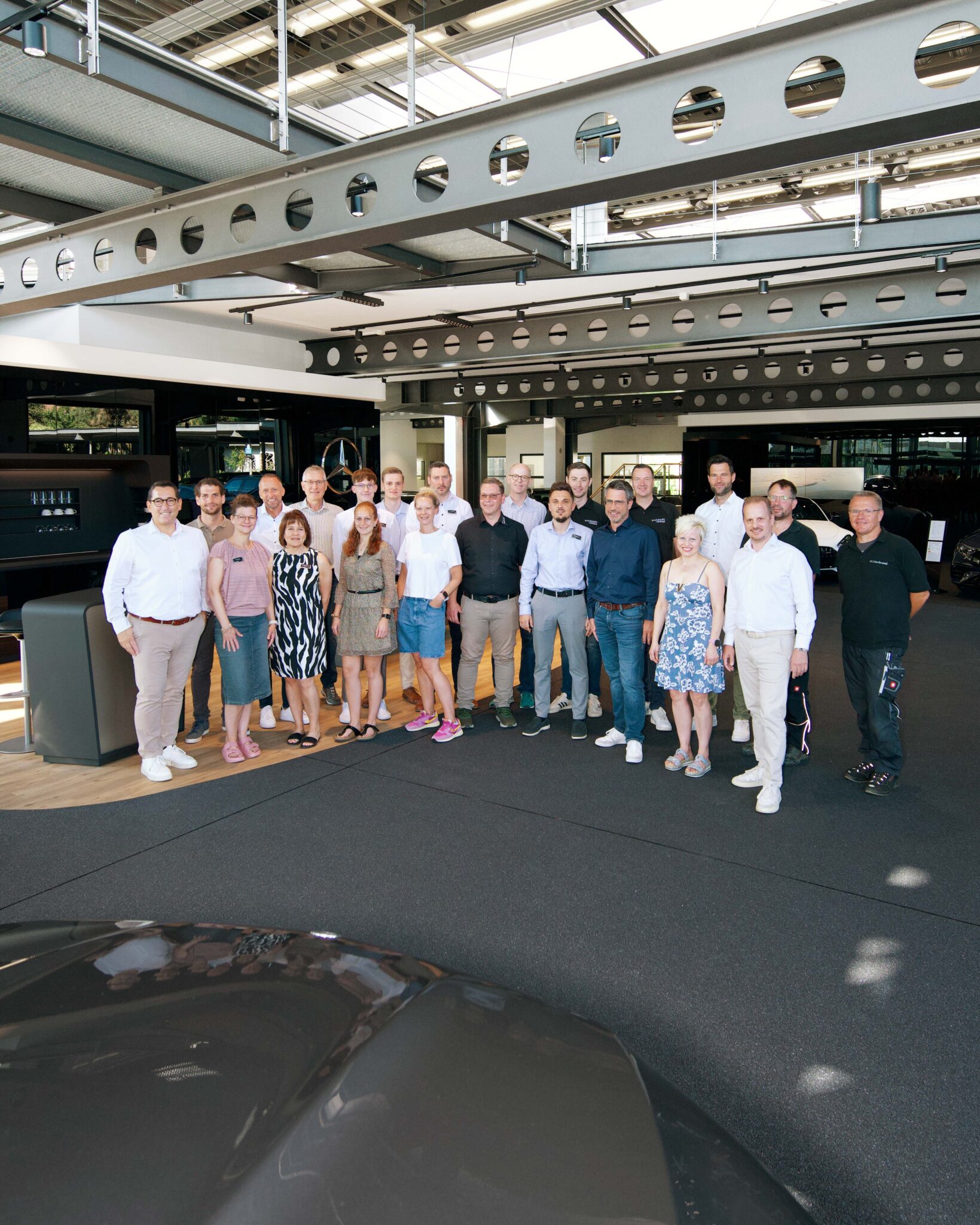 Gruppenfoto der Herbrand Mitarbeiter im neuen Pkw Shauraum in Kevelaer.