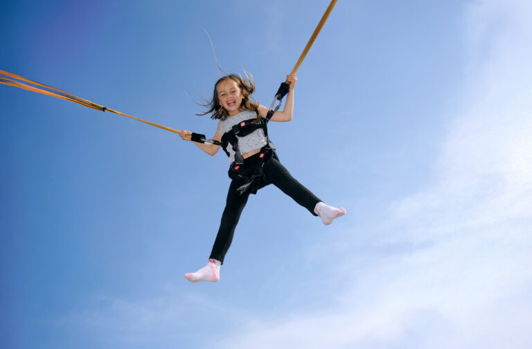 Junges Mädchen au einem Bungee-Trampolin.